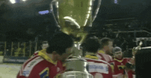 a group of hockey players holding a trophy with the word extra on it