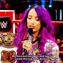 a woman with purple hair is holding a microphone and saying we have put our heart and soul to create this tag team division