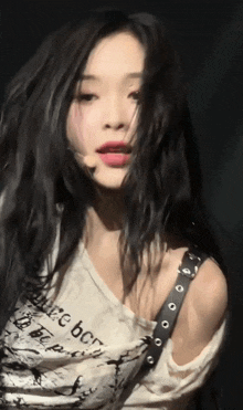 a woman with long black hair is wearing a white shirt that says " believe "