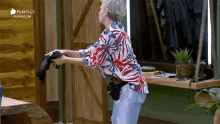 a woman is standing in a room holding a hair dryer in her hands .
