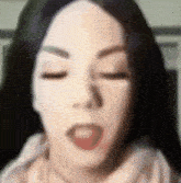 a close up of a woman 's face with her mouth open