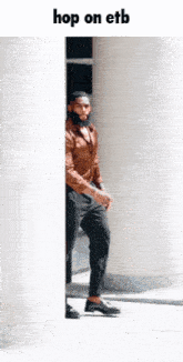 a man in a brown shirt and black pants is peeking out from behind a wall with the words hop on etb below him