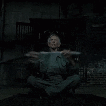 a man is sitting in a chair holding a sword in his hand .