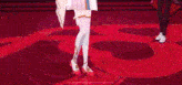 a woman in a white dress is dancing on a red floor .