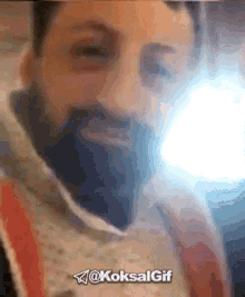 a man with a beard is smiling with the hashtag @koksalgif
