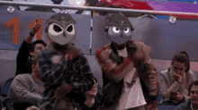 a group of people wearing owl masks in a stadium with the number 11 behind them