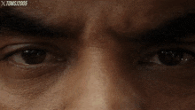 a close up of a man 's eyes with xtomsj2005 written above them
