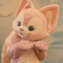 a close up of a stuffed animal that looks like a fox with big eyes .