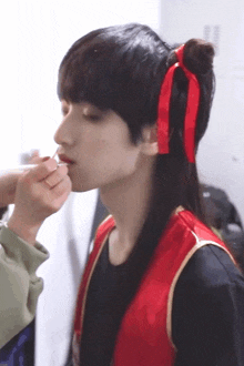 a woman is applying lipstick to a man 's lips