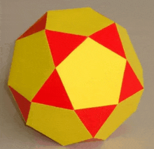 a yellow and red ball with a square in the middle is on a table .