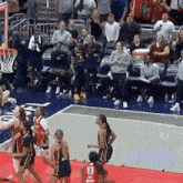 a group of female basketball players are playing a game on a court .