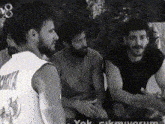 a group of men are sitting next to each other and talking .