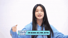 a girl wearing a blue hoodie with the name temen main on the front