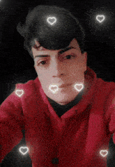 a young man in a red hoodie is surrounded by hearts