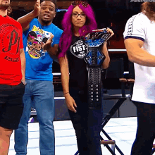 a woman with purple hair is holding a belt that says fist on it