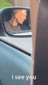 a man is reflected in the rear view mirror of a car with the words i see you above him