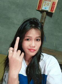a girl giving the middle finger in front of a calendar that says ' saigon ' on it