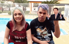 a man and a woman are sitting next to each other and the woman is wearing a shirt that says " monkey time " on it