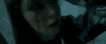 a close up of a woman 's face with her hand on her head .