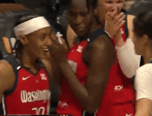 a woman wearing a washington jersey is clapping her hands