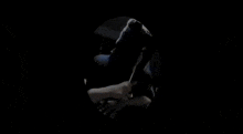 a person is sitting in a chair in a dark room in a dark room .