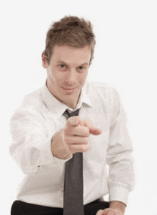 a man in a white shirt and tie is pointing