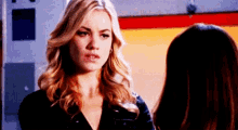two women are standing next to each other and talking to each other .
