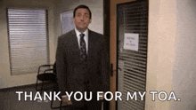 a man in a suit and tie is standing in front of a door and saying thank you for my toa .