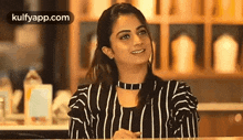 a woman is sitting at a table wearing a striped shirt and a choker .
