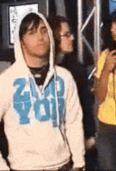 a man wearing a white hoodie with the word you on the front