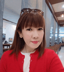 a woman wearing sunglasses and a red sweater is taking a picture