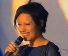 a woman singing into a microphone with raiuno written on the bottom of the screen