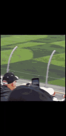 a man in a black hat watches a race
