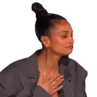 a woman with her hand on her chest and a bun on her head