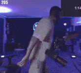 a man dancing in front of a microphone with the number 205 on the bottom right
