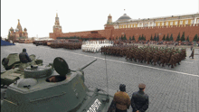 a group of soldiers are marching in a parade with a tank that says " zapypt " on the side of it