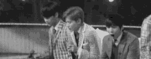 a group of young men are standing next to each other on a stage .