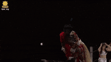 a man in a white and red costume is dancing in front of a black background