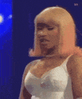 a woman with blonde hair is wearing a white tank top