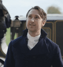 a man in a blue coat and white tie