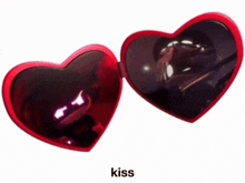 a pair of red heart shaped sunglasses with the word kiss below it