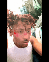 a man with dreadlocks has a flower on his forehead