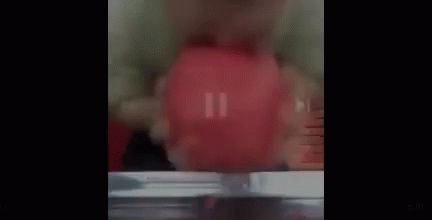 a close up of a person holding a red object in their hand .