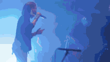 a woman singing into a microphone in front of a crowd