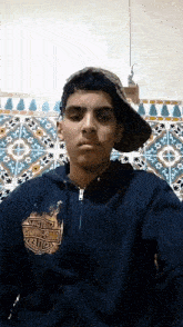 a young man wearing a harley davidson hoodie and hat