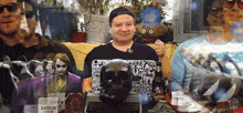 a man stands in front of a skull and a sign that says " satan city "