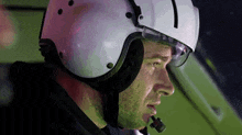 a man wearing a helmet and goggles is sitting in a car .