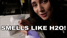 a woman is holding a device that smells like water