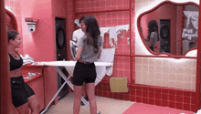 a woman is ironing clothes in a laundry room