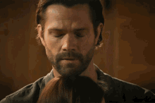 a man with a beard is touching a woman 's head